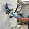 Person installing SL-F100 Separate Solar Wall Lamp with drill on outdoor wall.