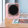Portable Energy Efficient Desktop Heater on a wooden desk next to glasses and magazines, providing quick warmth.