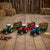 Farm Model Die-Cast Metal Series Toy Set with colorful tractors and logs on a wooden floor.
