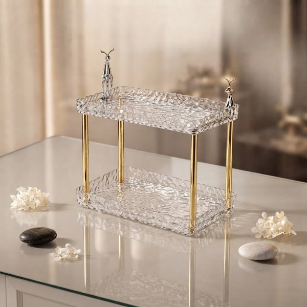 Double-Layer Water Ripple Beauty Organizer Shelf elegantly displayed on a vanity with decorative stones and flowers.
