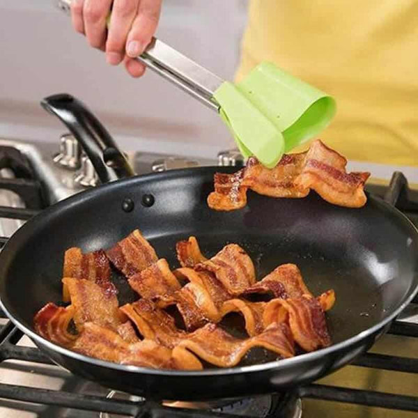 Using 2 in 1 Clever Tongs to flip crispy bacon in a skillet on the stove.
