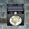 COB Solar Wall Light mounted on a stone wall, featuring a solar panel and LED illumination.
