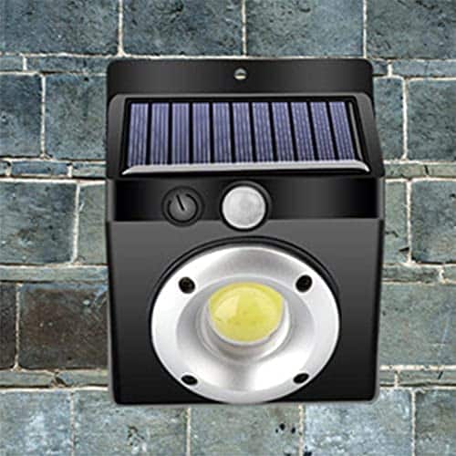 COB Solar Wall Light mounted on a stone wall, featuring a solar panel and LED illumination.