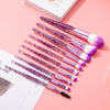10pcs Clear Crystal Quicksand Makeup Brush Set with pink and purple glitter handles on a pink background.