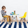 Kids Modern Plastic Chair with Wooden Legs next to a playful child coloring at a table in a bright space.