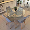 Round Glass 5 Piece Dining Set with Fabric Chairs featuring a sleek round glass table and modern fabric chairs.