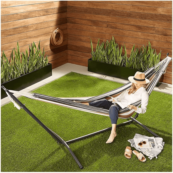 Portable Striped Hammock Swing Chair with a person relaxing outdoors in a garden setting.