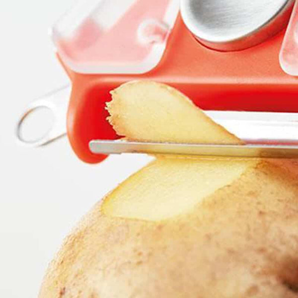 3 in 1 Peeler with Potato Eye Remover slicing through a potato skin in a close-up view.