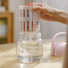 Person using a 2-in-1 Fresh Food Salad Tumbler to rinse fruits in a jar of water.