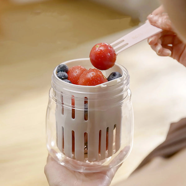 2-in-1 Fresh Food Salad Tumbler with fresh fruits being served using a fork for on-the-go meals.