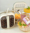2-in-1 Ice Ball Maker Bottle with Lid displayed with drinks and fruit in bowls.