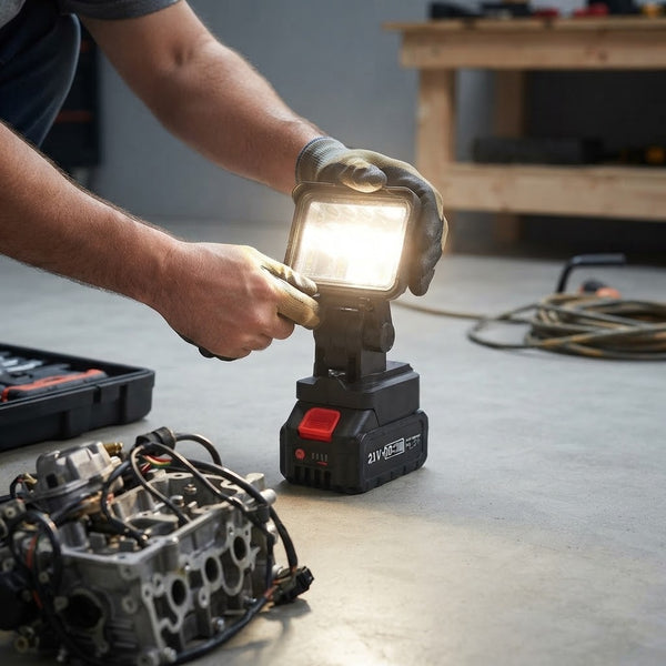A person using a 5-Inch Rechargeable LED Work Light in a workshop setting, providing bright illumination for tasks.