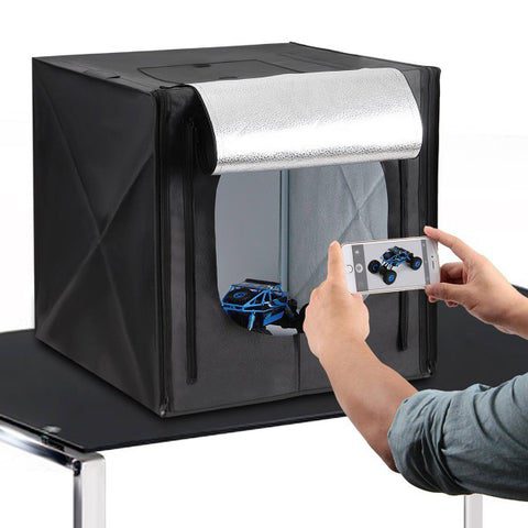 Person taking a photo of a model car inside a 60x60cm LED Deep Professional Photography Studio Light Box.