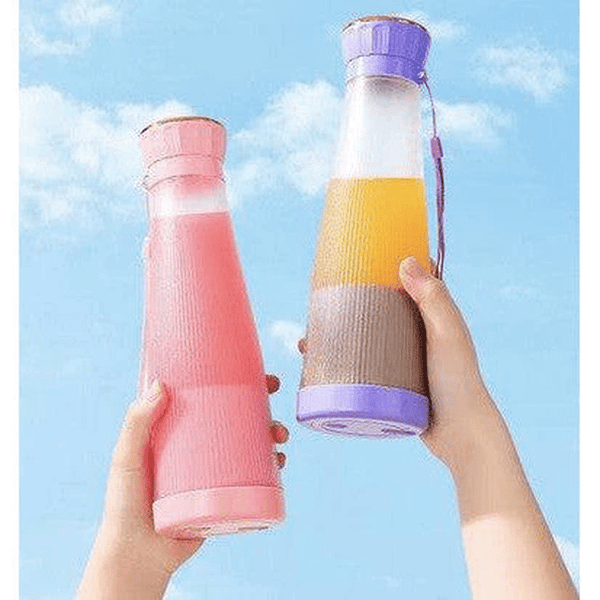 Two colorful Smoothie Blender Cups held against a blue sky, showcasing portable blending for healthy drinks.