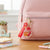 Heart-Shaped Liquid Glitter Keychain attached to a pink backpack, showcasing colorful glitter and decorative elements.