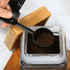 2 in 1 Coffee Scoop and Funnel being used to measure coffee grounds from a jar.