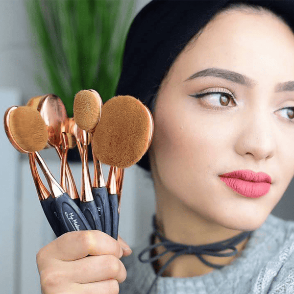 6 Piece Oval Makeup Brush Set held by a woman showcasing the versatile brushes for makeup application.