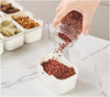 A person pouring ingredients into the 6-Compartment Snack Box with Lid for organized meal prep.