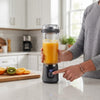 Digital Display Portable Juicer showcasing a person using the digital buttons to blend fresh juice in a modern kitchen.