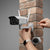 Installing the XY Wi-Fi Cam OD30 Bullet Security Camera Unit on a brick wall for outdoor surveillance.