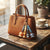 3D Animal Silicone Keychain hanging from a stylish brown handbag on a wooden table near a coffee cup.