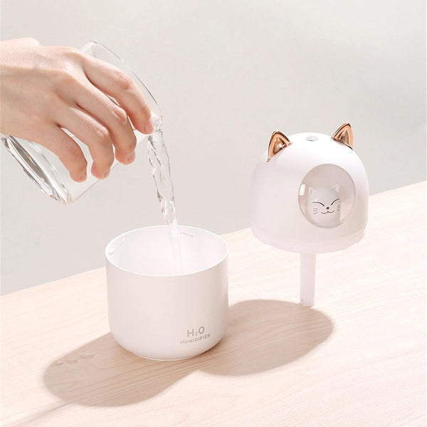 Person pouring water into the Portable USB Mini Cute Pet Cat Air Humidifier on a table.