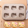 Cartoon Character Non-Stick Baking Pan with six Hello Kitty shaped molds and decorated cookies.