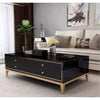 Four Drawer Coffee Table with a sleek black finish and gold accents, placed in a modern living room setting.