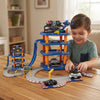 Child playing with 66-Piece Police Station Multi-Level Track Set featuring cars and a multi-level police station.