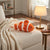 Orange and White Striped Clownfish Plush Toy resting on a cozy sofa with a warm lamp nearby.