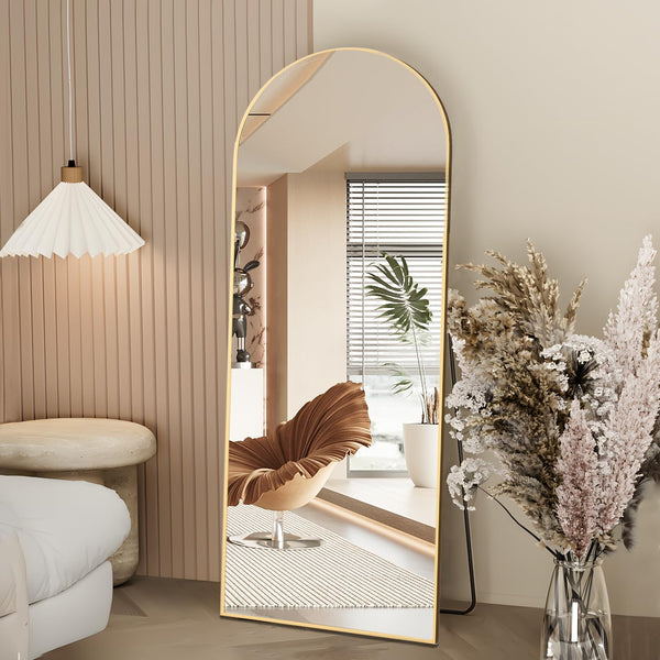 Arched Full Length Floor Mirror with Gold Frame reflecting light in a modern living room setting