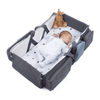 Baby sleeping in the 2 in 1 Travel Baby Bed & Bag with soft blanket and stuffed toy.