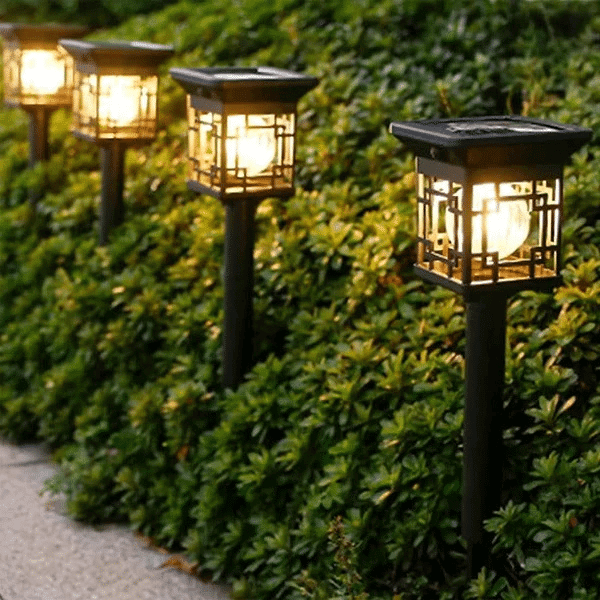 2-Pack Solar Garden Lights illuminating a pathway among lush greenery for outdoor ambiance.