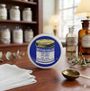 Mentholtianlan Medicated Relief Balm on a wooden table, surrounded by herbal ingredients and vintage jars.