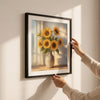 Person hanging 50x50 Sunflower Canvas Wall Art featuring bright sunflowers in a rustic vase.