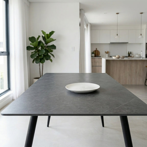 6 Seater Dining Table with plate on top, modern design in bright dining space with greenery.