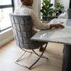 Grey Upholstered Dining Chair with Silver Frame showcased in modern dining space.