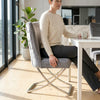 Grey Upholstered Dining Chair with Silver Frame, featuring padded seating and stylish design in a modern dining area.