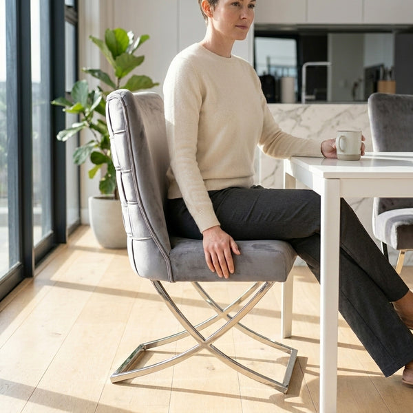 Grey Upholstered Dining Chair with Silver Frame, featuring padded seating and stylish design in a modern dining area.