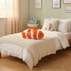 Orange and White Striped Clownfish Plush Toy on a cozy bed, perfect for playful bedroom decor and cuddles.
