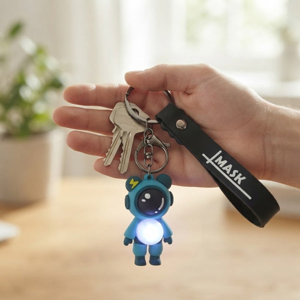 Colorful Astronaut Bear LED Keychain with Wrist Strap illuminating keys in hand.