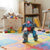 Battery-Operated Stunt Rolling Gorilla Toy performing stunts in a colorful playroom with toys and stuffed animals.