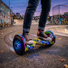 Person riding an Electric Self-Balancing Hoverboard with colorful design and LED lights on a graffiti-covered street.