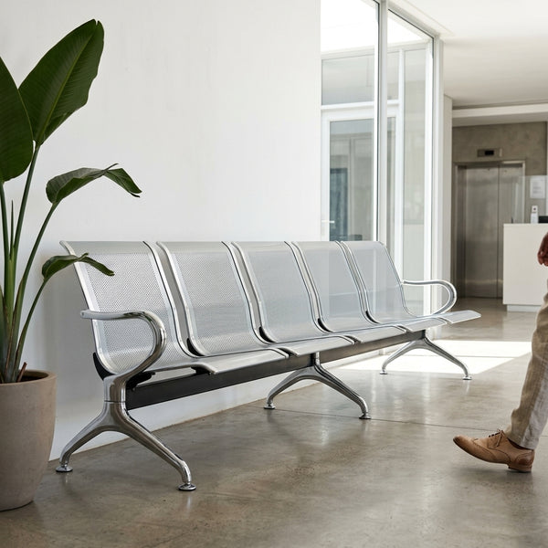 Heavy-Duty Stainless Steel Public Seating Bench in modern waiting area with plants.
