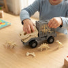 Child playing with Dinosaur Fossil Truck Playset, featuring dinosaur skeletons and a truck design.