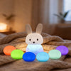 Little Bunny Silicone Night Light illuminating a cozy space surrounded by colorful glow eggs.
