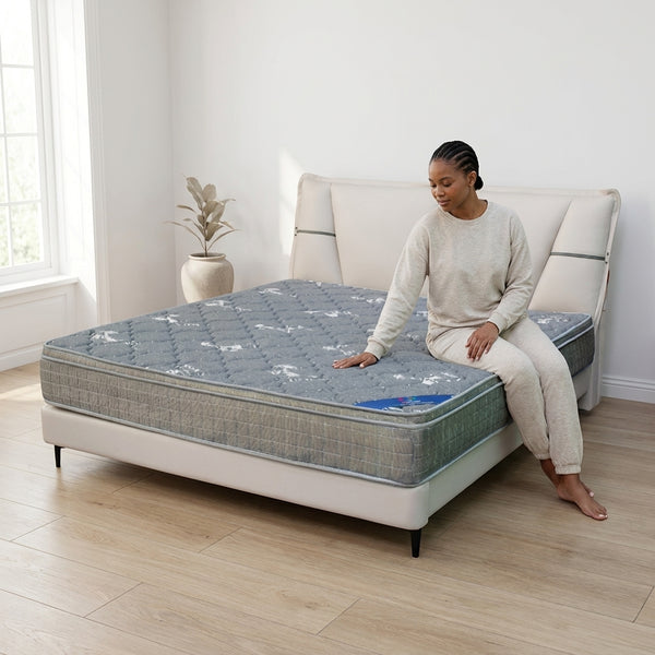 Modern Upholstered Bed Frame with a comfortable mattress and a woman sitting on it in a bright bedroom setting.