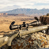 Rifle Scope on a rifle with a scenic mountainous background, showcasing its design and functionality.