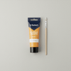 Acrylic Paint 75ml - Orange Yellow tube alongside a paintbrush on a neutral background.