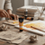 Acrylic Paint 75ml - Orange Yellow tube on a crafting table with paint palettes and brushes.